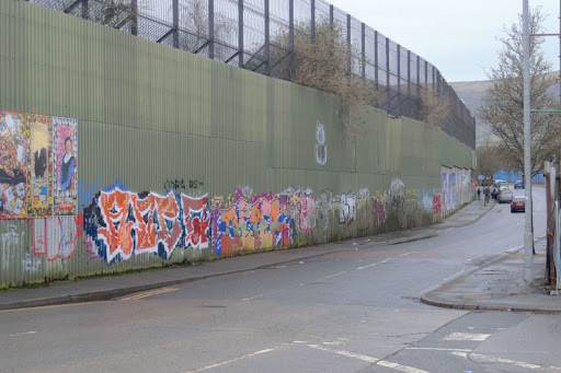 Photo of Cupan Road Peace Wall. A large metal fence taller than a two storey house.